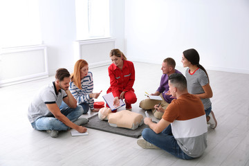 Group of people with instructor at first aid class indoors - obrazy, fototapety, plakaty