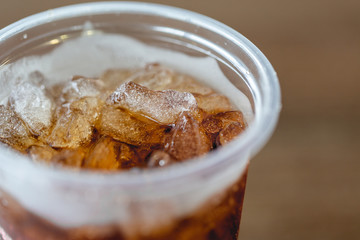 Close up of ice cubes with cola in the plastic glass