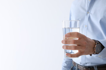 Man holding glass of pure water on white background, closeup. Space for text