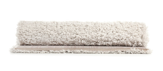 Fototapeta na wymiar Rolled fuzzy carpet on white background. Interior element
