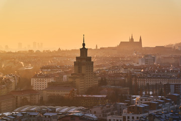Morning cityscape picture of Prague 6 taken in golden hour shows contrast between communist arechitecture and old gotic architecture catedhral of Saint Vitus in castle.