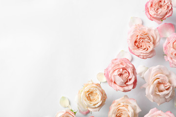 Fototapeta premium Flat lay composition with beautiful roses and space for text on white background