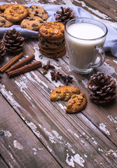 Treats for Santa Claus freshly baked natural biscuits with cup of milk on a wooden background.