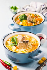 Fish soup with salmon, vegetables and couscous in blue pots. Selective focus, space for text.