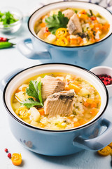 Fish soup with salmon, vegetables and couscous in blue pots. Selective focus, space for text.