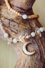 Moon pendant mineral stone beads necklace on wooden background