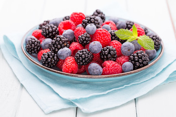 Fresh raspberries in a plate on a  vintage background.