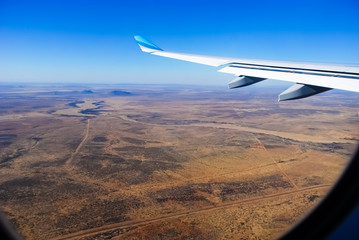 View through the window of a passenger plane flying above Namibia, Africa, taken just a minute before landing at the Windhoek Airport