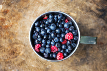 cup of raspberries and blueberries