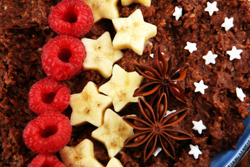 Bowl of cacao oatmeal porridge with banana, raspberries coconut and caramel sauce on rustic table, hot and healthy food for Breakfast
