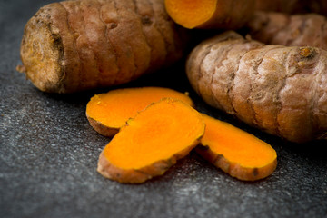 turmeric slices close up on gray background
