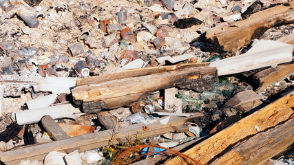 Garbage, metal, cans, broken glass, burnt logs after the fire.Garbage that are difficult to remove or decompose.