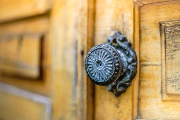 old wooden door with a round iron handle, close-up.