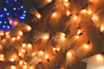 Christmas lights in the form of leaves on wooden background with copy space.