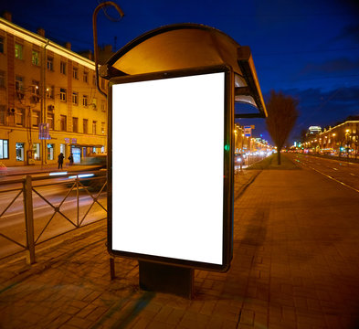Billboard on the street Outdoor Advertising glows at night. Layout for advertising design. Lightposter pylon with a white field. bus shelter