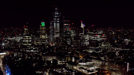 Aerial View of Urban City at Night. Modern High Rise Buildings and Office Towers in Business and Financial District. High Up Shot of London City Skyscrapers Lit Brightly