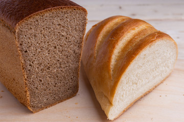 traditional russian, types of baked bread cut, rye brick and loaf on wooden desk, top view, closeup, vertical