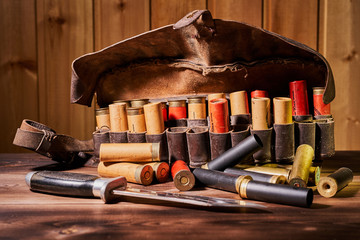 Old hunting cartridges and bandoleer on a wooden table