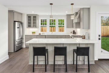 Kitchen in New Home with Bar Seating and Stainless Steel Appliances 