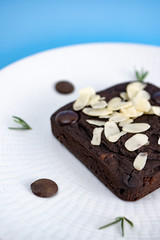 Chocolate Brownie with almond slice in white plate.