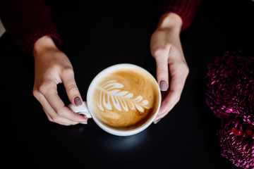 Cup of cappuccino in hand