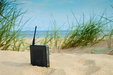 router on the sand on a summer day, the concept of modern technology, remote work, a network for...