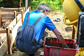 Production of cement mortar in a concrete mixer. The construction of the formwork for a fence.