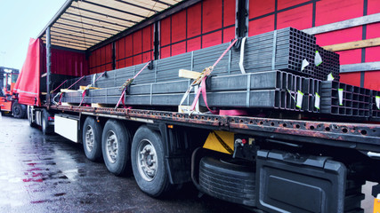  There is a loading to the truck trailer .  fastening of freight in the trailer .   transportation of freight Europe . industrial infrastructure . to fix freight .  Cargo container . 