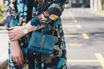 Close-up of a woman wearing a watch and holding a purse