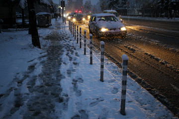 Snow in the city. Winter snow fall landscape. Street covered with snow and ice. Road in winter time. Cold concept. Snowstorm. 