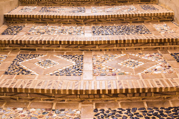 Closeup of the staircase of the old city, paved with a stone in the form of a picture. Mediterranean architecture in Spain.