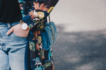 Close-up of a woman wearing a watch and holding a purse