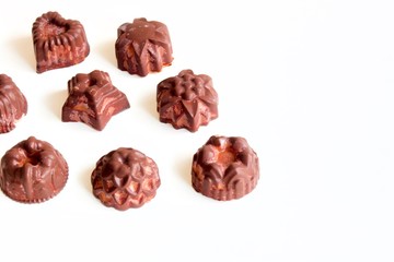 Tasty dark chocolate candies on the white background