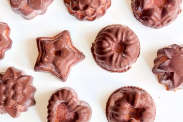 Tasty dark chocolate candies on the white background