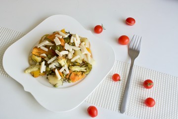 Tasty vegetable stew on the white plate with red tomatoes