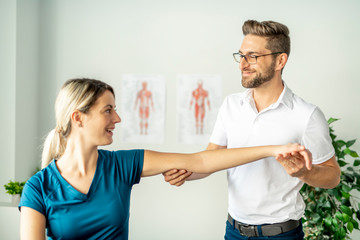 A Modern rehabilitation physiotherapy man at work with woman client