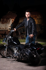 Fototapeta na wymiar Cute motorcyclist stands near his motorcycle 