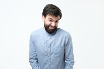 Fototapeta premium Sly young hispanic man imploring for a favor making a funny grimace.