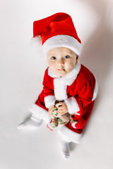 Beautiful little baby celebrates Christmas. New Year's holidays. Baby in a Christmas costume holds in the hands of a Christmas reindeer