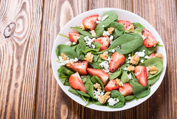 Strawberry salad with spinach , cheese and walnut . Healthy food