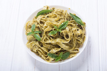 Pasta tagliatelle with green sauce pesto . Italian food background