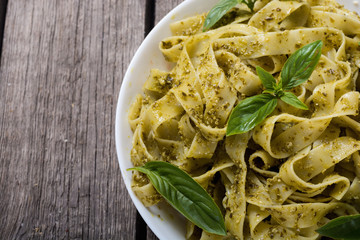 Pasta tagliatelle with green sauce pesto . Italian food background