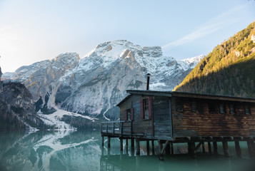 Dolomites, Italy. A view of mountains, forest and a blue lake. A hut in the foreground