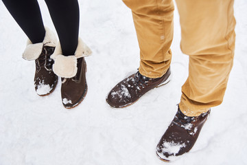 couple in love wear brown boots stay on white fresh snow