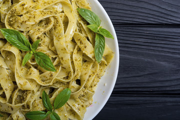 Pasta tagliatelle with green sauce pesto . Italian food background