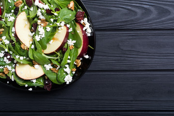 Autumn spinach salad with apple , cheese , walnut and dried cranberry . Healthy vegetarian food