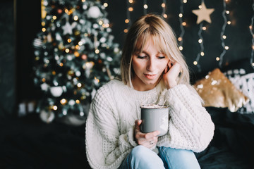 New Year portrait of a girl in beautiful interior. Girl with coffee in bed in the new year interior. Christmas and  Happy New Year concept