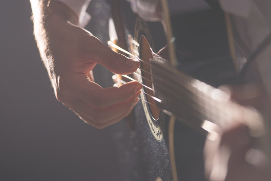 Musician plays guitar hands on strings close up. Theme music. 