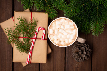 Close-up of gifts wrapped with craft paper, decorated with candy cane and cup mug of coffee cacao on a rustic dark wooden table. Christmas concept. New Year concept. Gifts. presents. Holiday concept