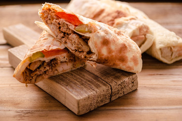 Doner Kebab Gyros Shawarma beef roll in pitta bread Wrap sandwich on wooden background